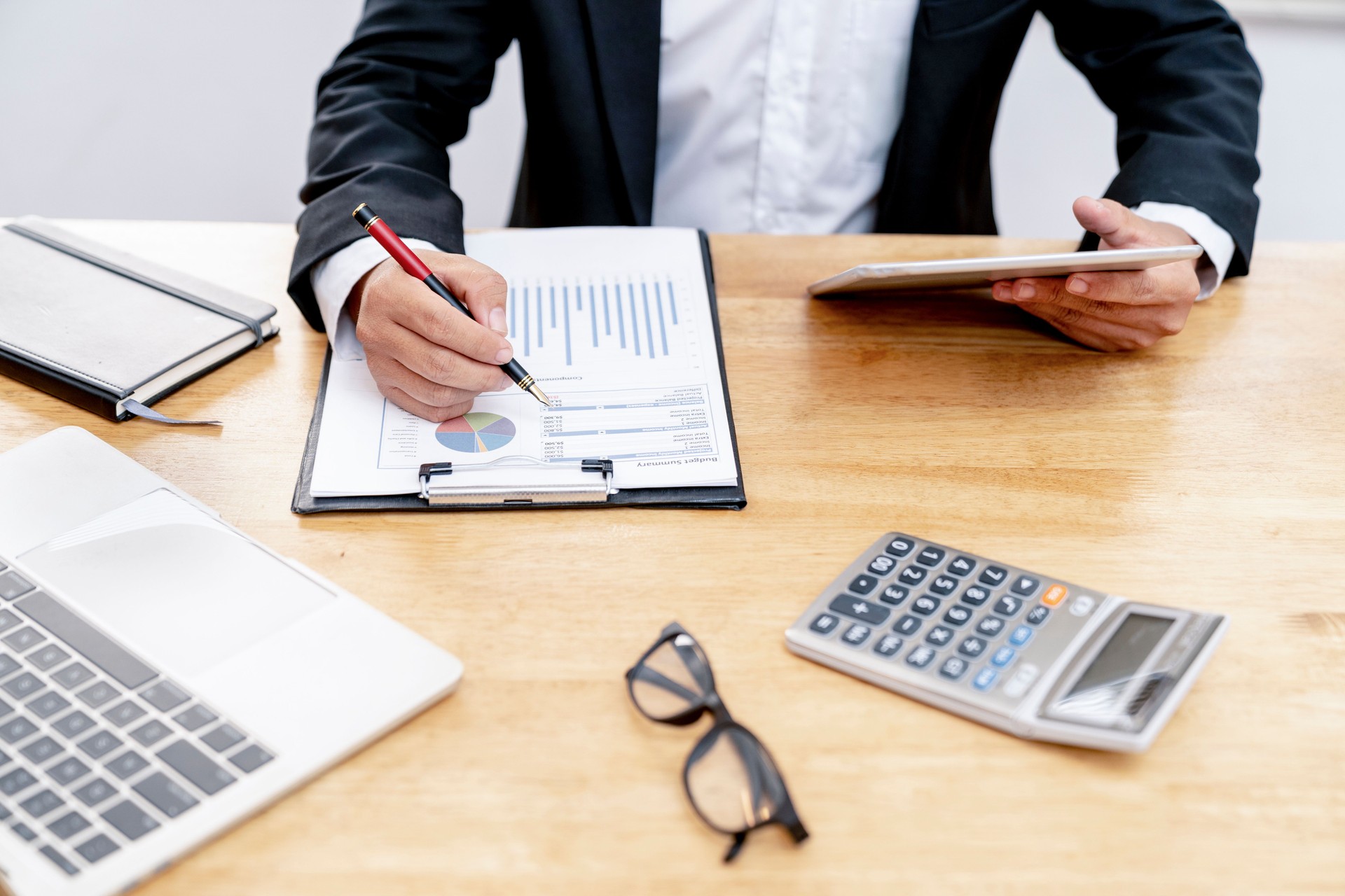 Démarrage, homme d’affaires ou un comptable vérifiant son graphique d’affaires travaillant sur le calculateur sur la table de bureau et ordinateur portable.